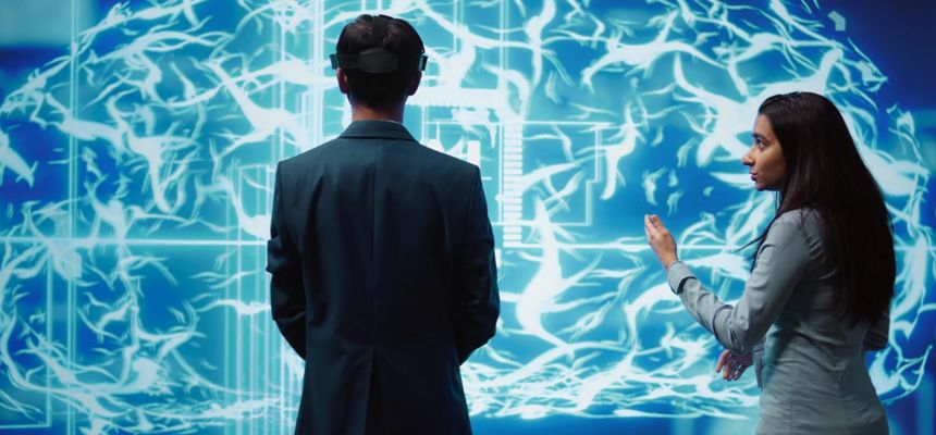 Homem com dispositivo na cabeça observa uma tela com padrões neurais luminosos, enquanto uma mulher ao lado aponta para ela. tela com padrões neurais luminosos, enquanto uma mulher ao lado aponta para ela.