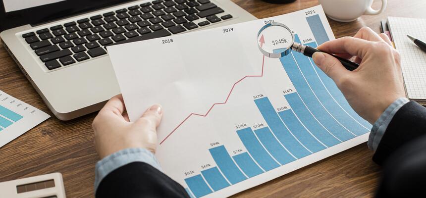 Profissional analisa gráfico de desempenho com barras crescentes e linha ascendente usando uma lupa, representando a otimização do CTR (Click-Through Rate) e resultados em social ads